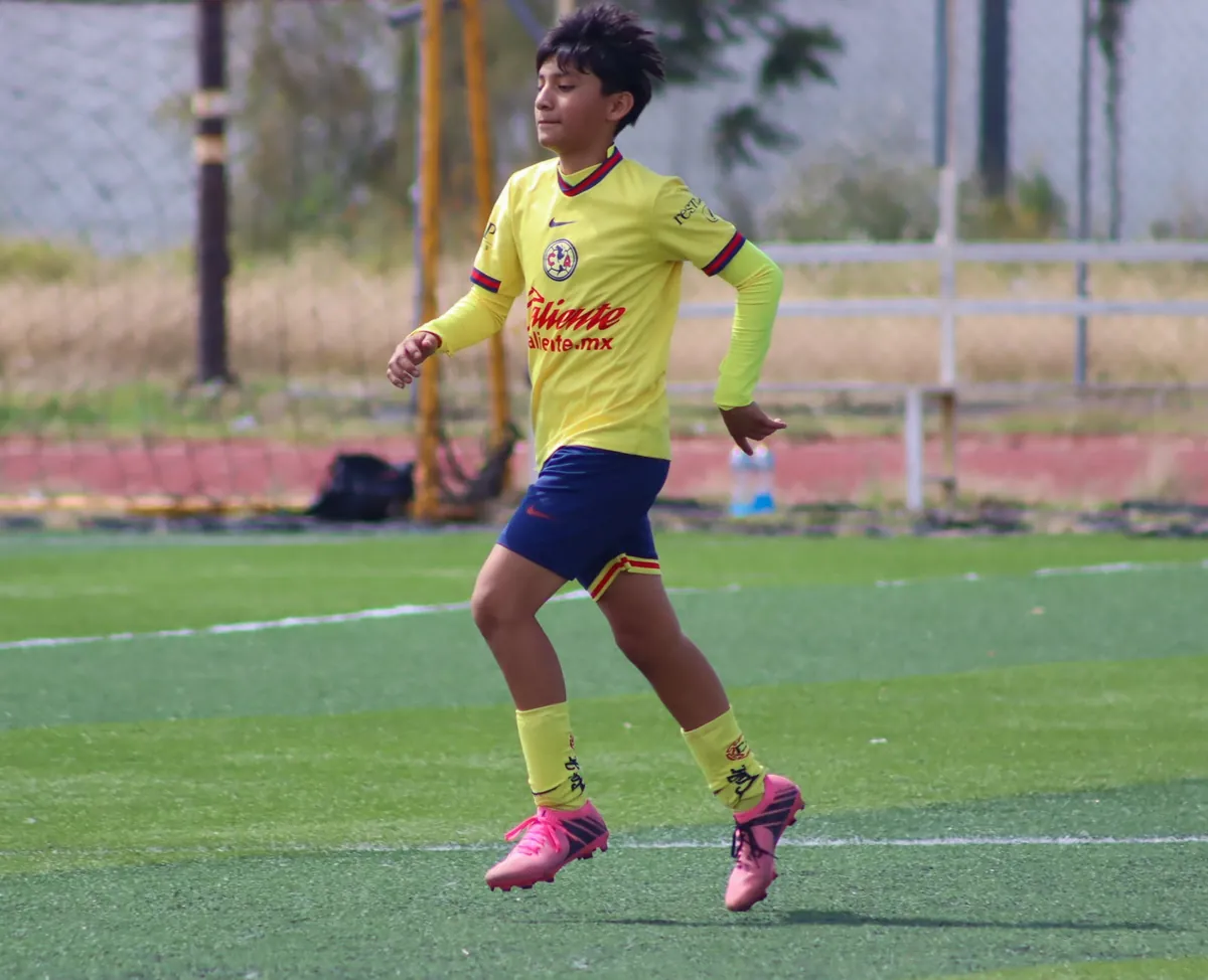 Jugador de Nido Águila con camiseta amarilla corriendo por la cancha
