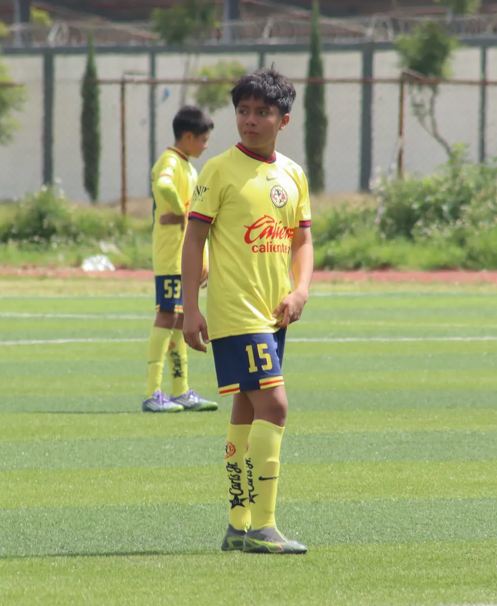 Jugador número 15 de Nido Águila de pie en la cancha con un compañero al fondo